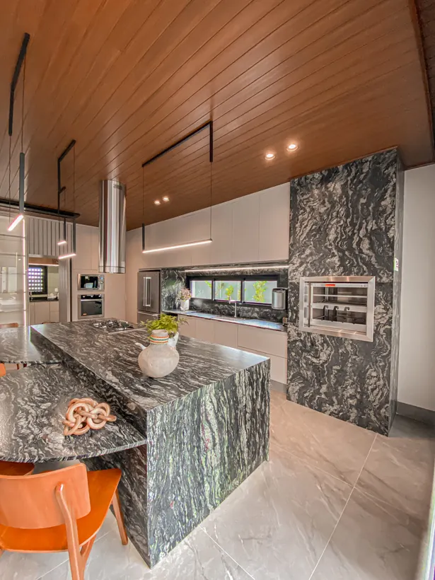 Ilha de granito com coifa e cooktop